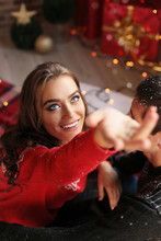 Christmas Photo Of Beautiful Woman With Dark Hair In Cozy Clothes Posing At Home
