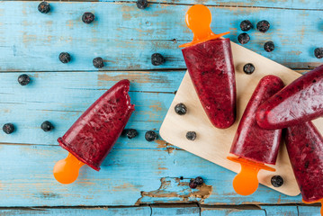 Wall Mural - Delicious home-made popsicles of black currant. On a wooden table, copy space