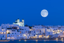 Local Church Of Naoussa Village At Paros Island In Greece Against The Full Moon.
