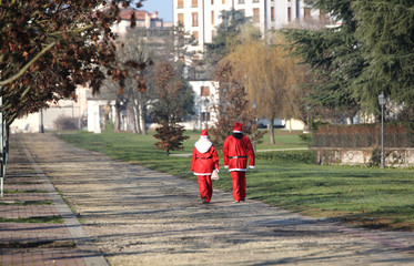 two Santa Claus walking on the Public Park at Christmas