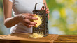 Woman's hands with grater and cheese