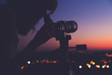 Wall Mural - girl looking at the stars through a telescope.