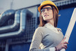 beautiful woman engineer is standing in front of an industrial pipes background