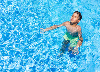 Happy children on summer vacation swimming pool having fun and h