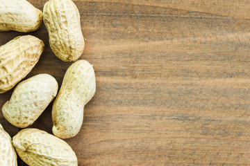 Wall Mural - close up dried peanuts on wood table texture with copy space, top view