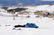 man lying on cold snow after ski crash at Sierra Nevada resort in Spain with mountains