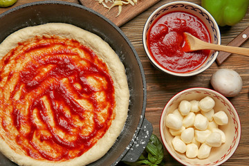 Sticker - Unbaked pizza in pan on wooden table