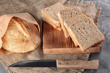 Wall Mural - Sliced fresh bread on wooden cutting board closeup