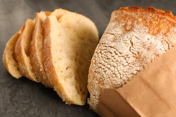 Wall Mural - Sliced fresh bread on black table closeup