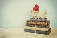 Wooden Plane With Heart On The Stack Of Old Books