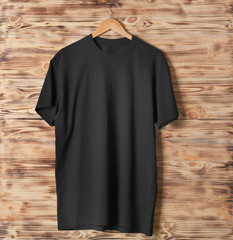 Blank black t-shirt against wooden background