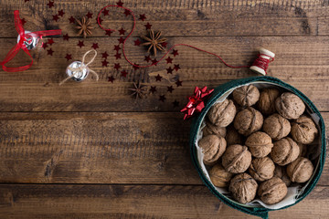 Walnuts in Festive Tin with Christmas Decorations on Rustic Wooden Table