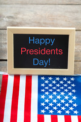 the text happy presidents day written in a chalkboard and a flag of the United States