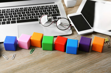 Wall Mural - Laptop and wooden cubes on color background