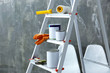 © Africa Studio - Ladder and set of tools for repair near grunge wall, closeup