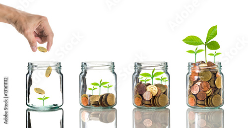 Fotografía Hand putting gold coins into clear bottle on white background,Bu