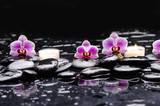 Fototapeta Kwiaty - Pink orchid and white candle on black stones