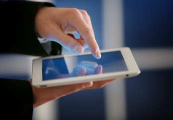 Male finger touching tablet screen on blurred background