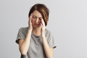 girl suffers from terrible headaches and compresses the head with hands