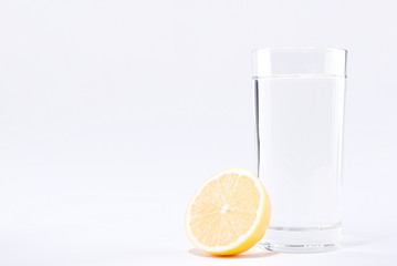 Wall Mural - glass of water with lemon on a white background