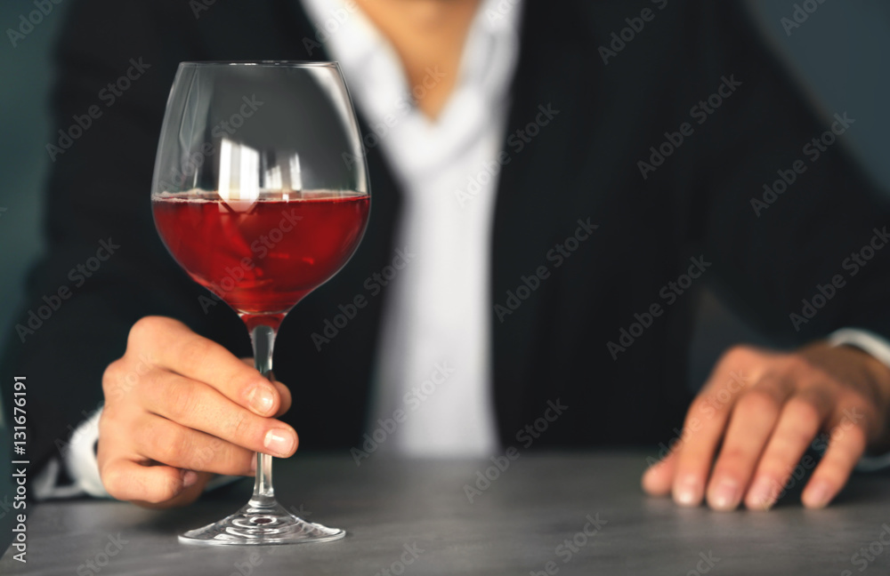 Man holding glass with wine on blurred background