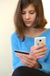 Молодая девушка в голубом свитере с банковской картой и сенсорным телефоном в руках, банковские платежи 