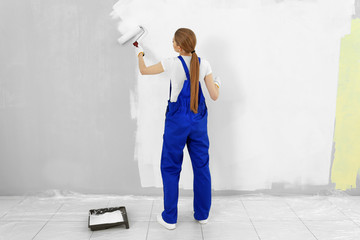 Poster - Beautiful young woman painting wall in room