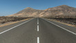 © alphafotorist - Gerade Asphalt-Straße durch Lavafelsen