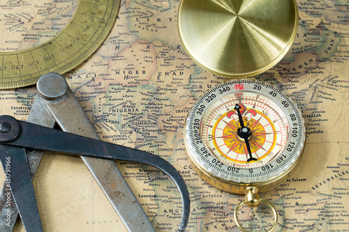Zdjęcie XXL Stary pomiarowy narzędzie złota kompas z pokrywą na rocznik mapie, makro- tło, kompasy