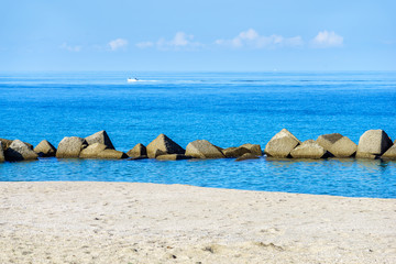 Wall Mural - stones breakwater near beach of Tonarella