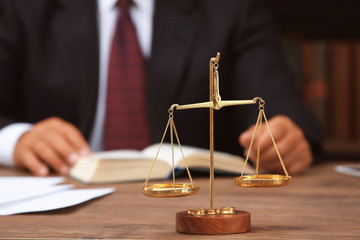 Sticker - Scales of justice on wooden table and male lawyer on background