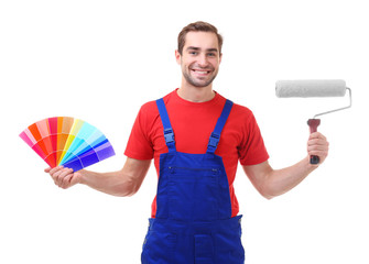 Wall Mural - Young decorator holding color samples and paint roller, on white background