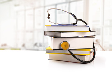 medical education - stack of books with stethoscope on the table
