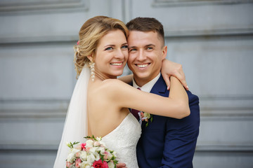 Wedding couple, portrait of happy bride and groom on background with copy space. Young and beautiful couple in love with smiling faces at their wedding day