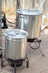 Two home brew kettles boiling wort with propane tank