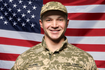 Wall Mural - Soldier in camouflage with USA flag on background