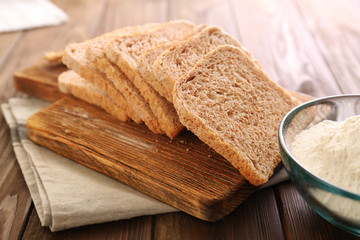 Poster - Sliced bread on wooden cutting board closeup