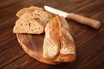 Wall Mural - Sliced bread with knife on wooden background