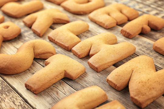 Cookie alphabet on wooden background, closeup