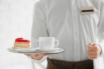 Canvas Print - Waiter in white shirt bringing the ordered dessert and cup of coffee in a cafe, close up