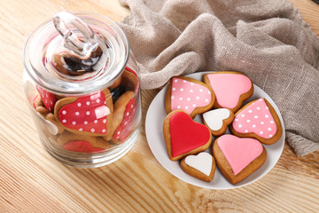 Wall Mural - Valentine's day cookies in glass jar and on plate against wooden background