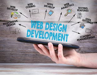 Web Design and Development concept. Tablet computer in the hand. Old wooden background.