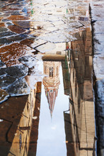 Tower Reflected In Puddle On Street
