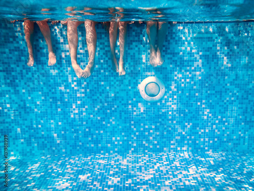 Fotografía Children's and adults legs underwater in swimming pool