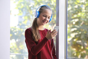 Wall Mural - Cute teenager listening music on window background