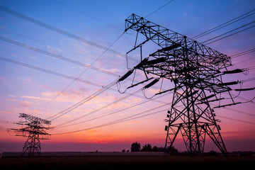 The silhouette of the evening electricity transmission pylon