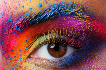close up view of female eye with bright multicolored fashion mak