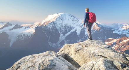 Wall Mural - tourist on the peak of high rocks. sport and active life concept