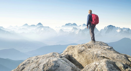 Wall Mural - tourist on the peak of high rocks. sport and active life concept..