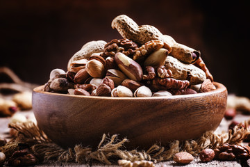 Wall Mural - Nuts mix in a bowl on the old wooden background, selective focus